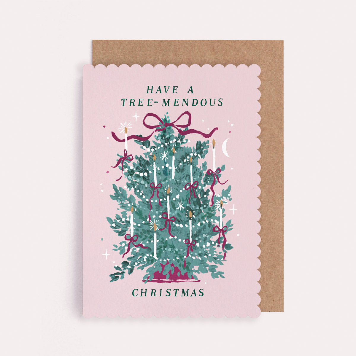 Christmas card with a decorated tree and have a tree-mendous Christmas text on a pink background