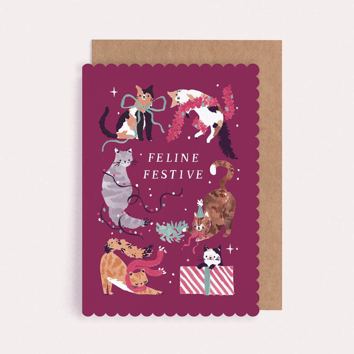 Christmas card with illustrations of cats and the text 'Feline Festive' cut into a unique scallop shape.