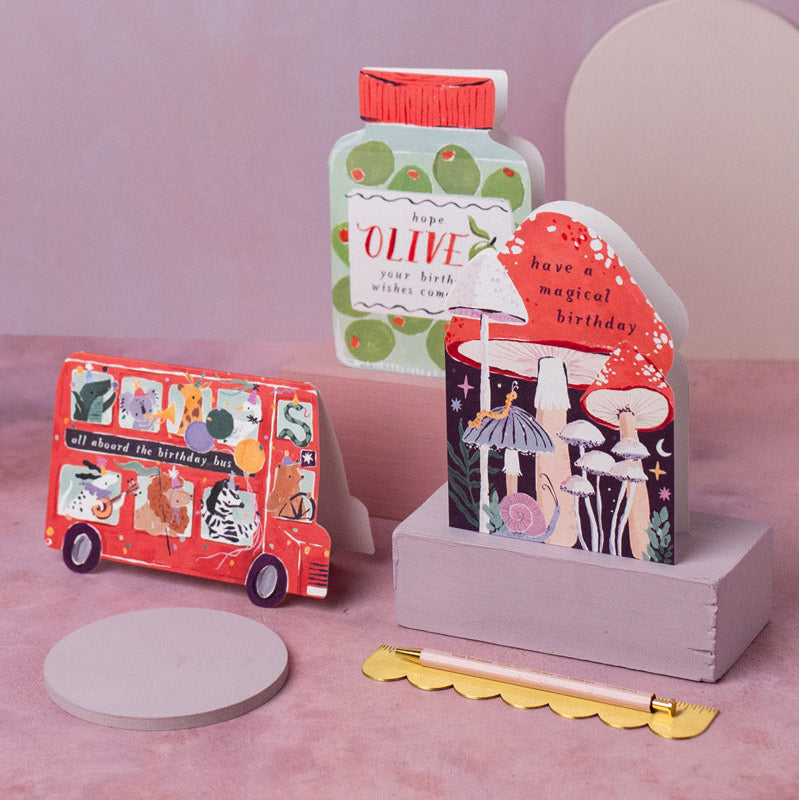 Children's birthday card cut into a bus shape filled with adorable animals riding along in the party bus.