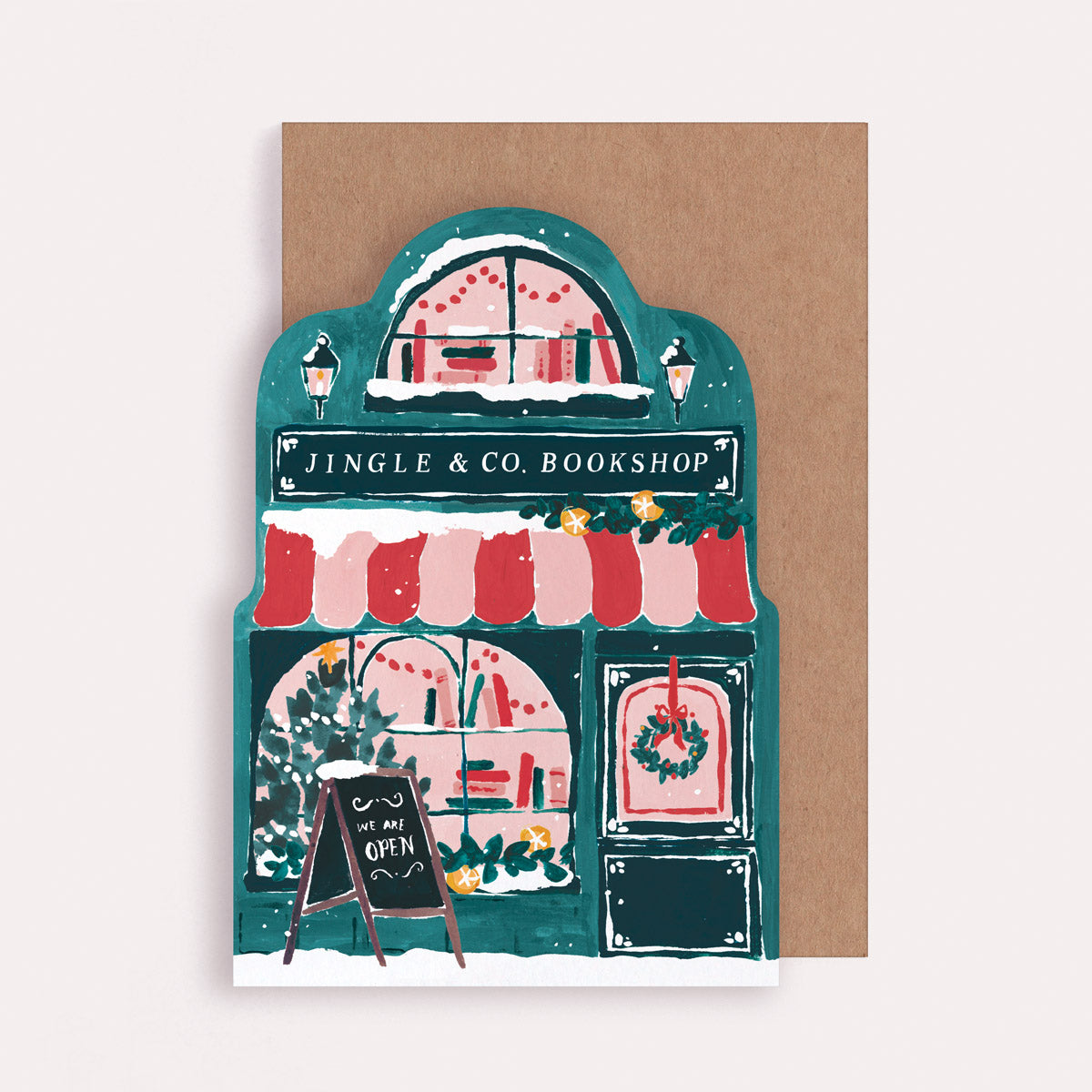 Christmas card with illustration of a bookshop named 'Jingle & Co. Bookshop'. The greeting card is cut into a unique shape of a book store.
