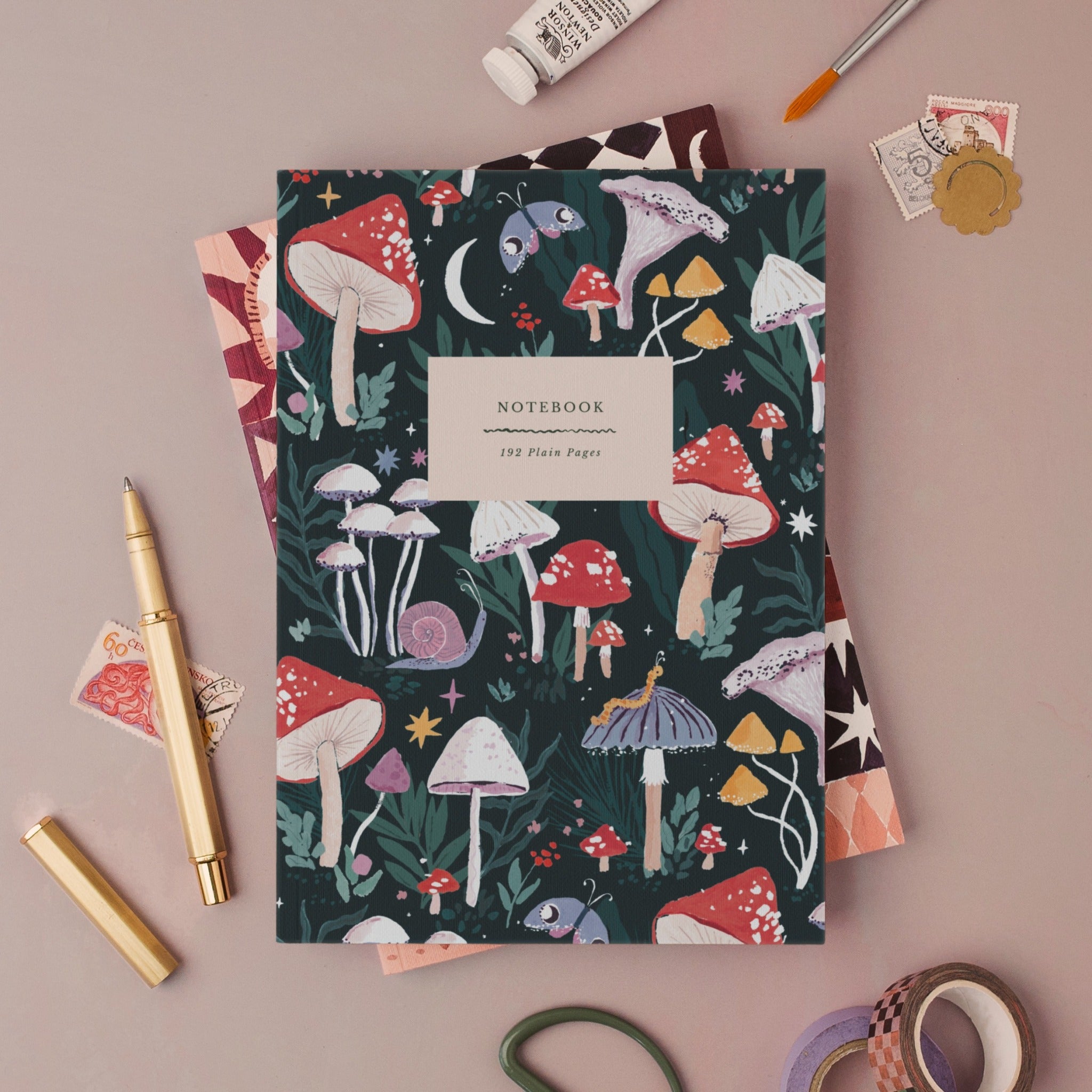 Mushrooms notebook, A5 plain page journal styled in a flat lay with a gold pen, paints and vintage stamps