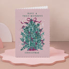 Christmas card with a decorated tree and 'Have a Tree-mendous Christmas' text on a pink scalloped edge stand.