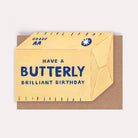 Butter-shaped funny foodie birthday card with the caption 'Have a Butterly Brilliant Birthday'