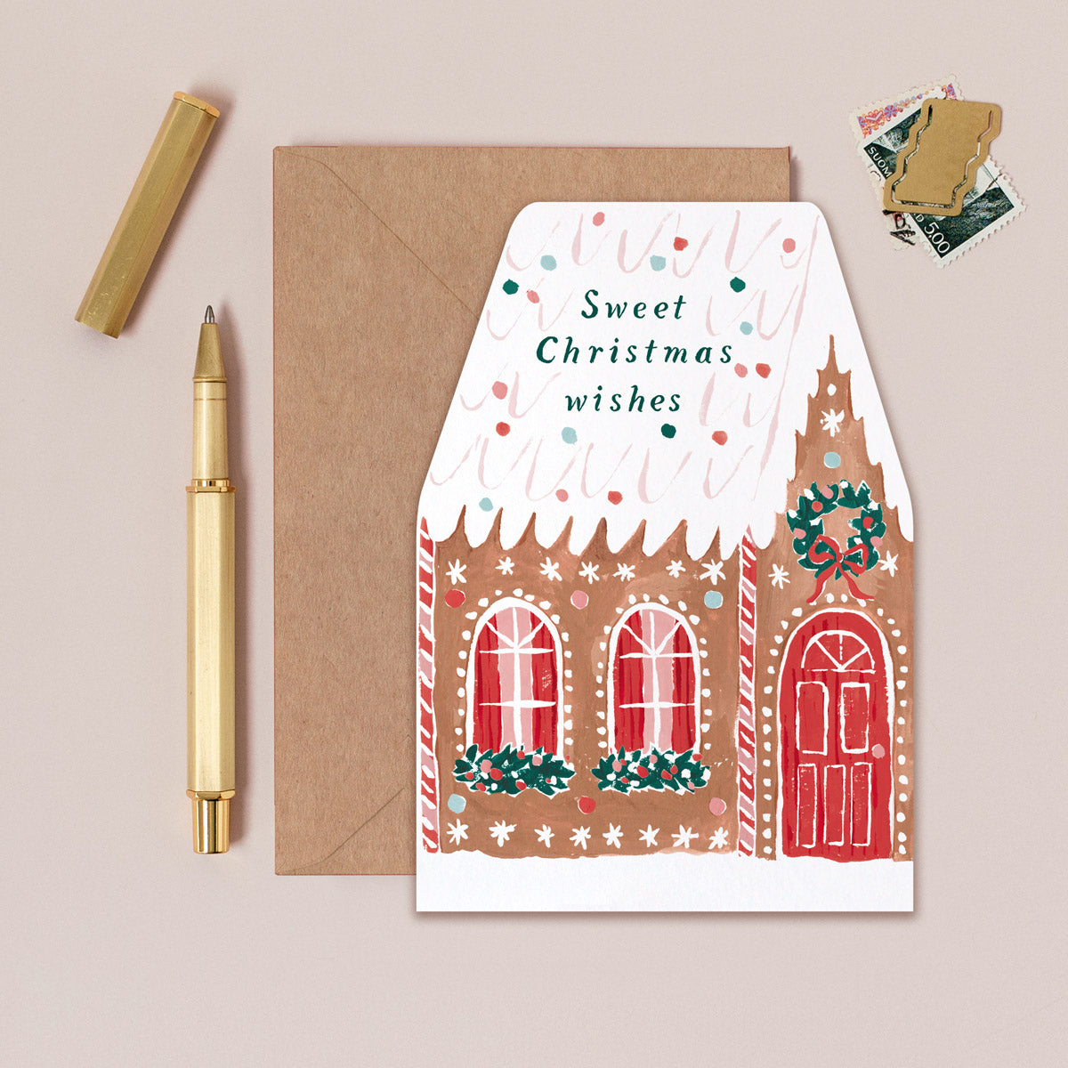 A Christmas card cut into the shape of a gingerbread house from the wholesale Christmas card collection at Sister Paper Co.