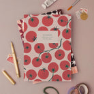 Tomatoes notebook, A5 plain page journal styled in a flat lay with a gold pen, paints and vintage stamps