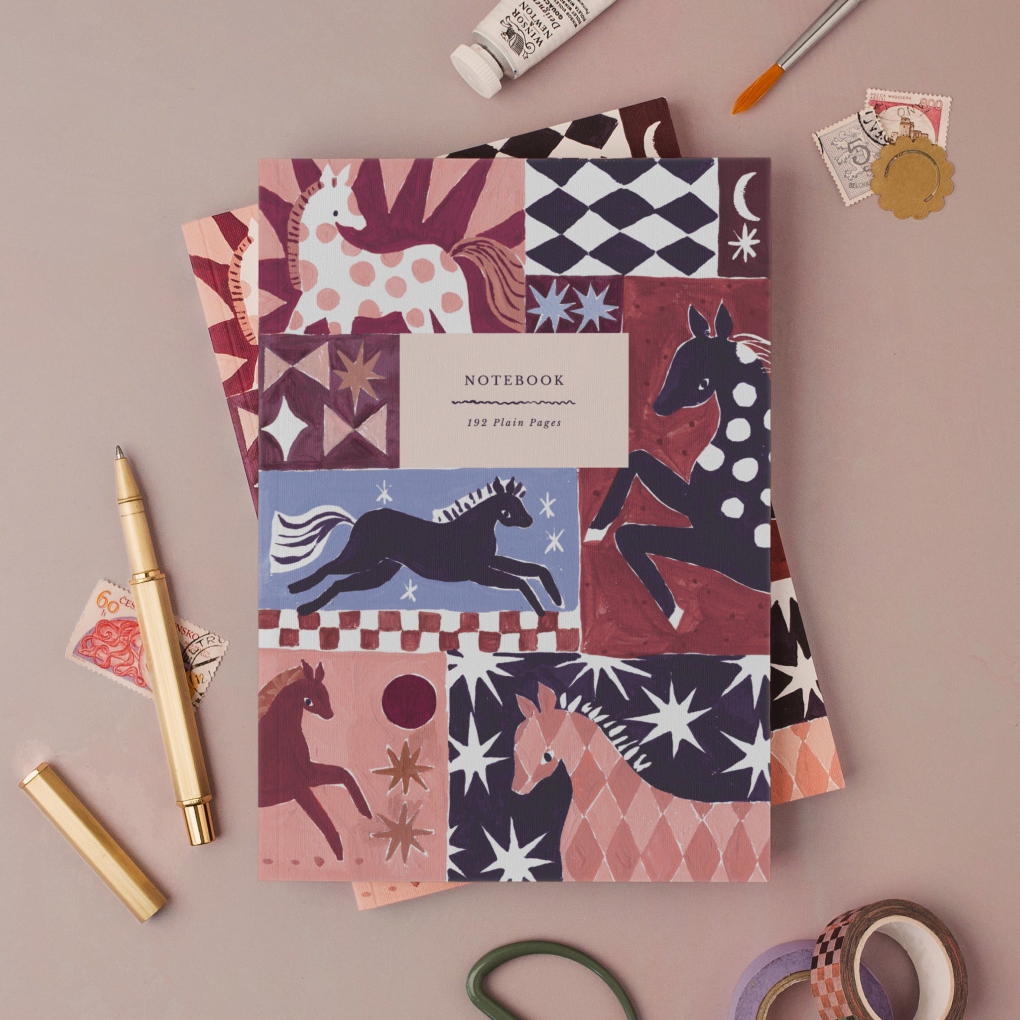 Wild & Free horse notebook, A5 plain page journal styled in a flat lay with a gold pen, paints and vintage stamps
