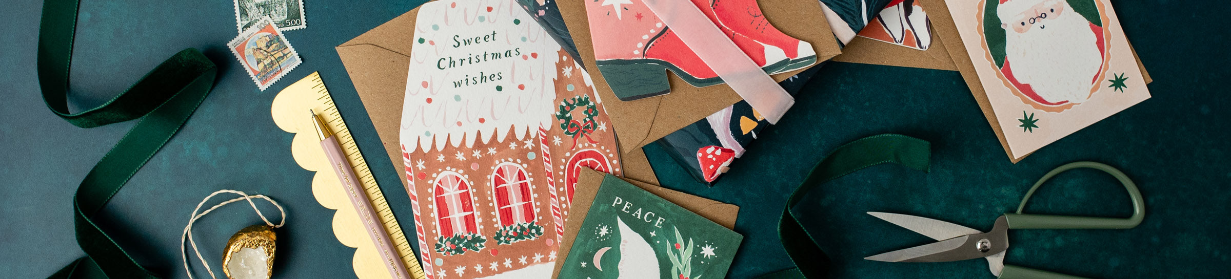Collection of Christmas cards with Santa Claus, trees, and other festive designs on a dark green background.